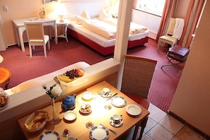 Habitación de hotel con comedor, cama y baño.