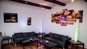 A modern living room with a sectional sofa, two coffee tables, and artwork on the walls. - Parkhotel Fischer (Wernigerode)
