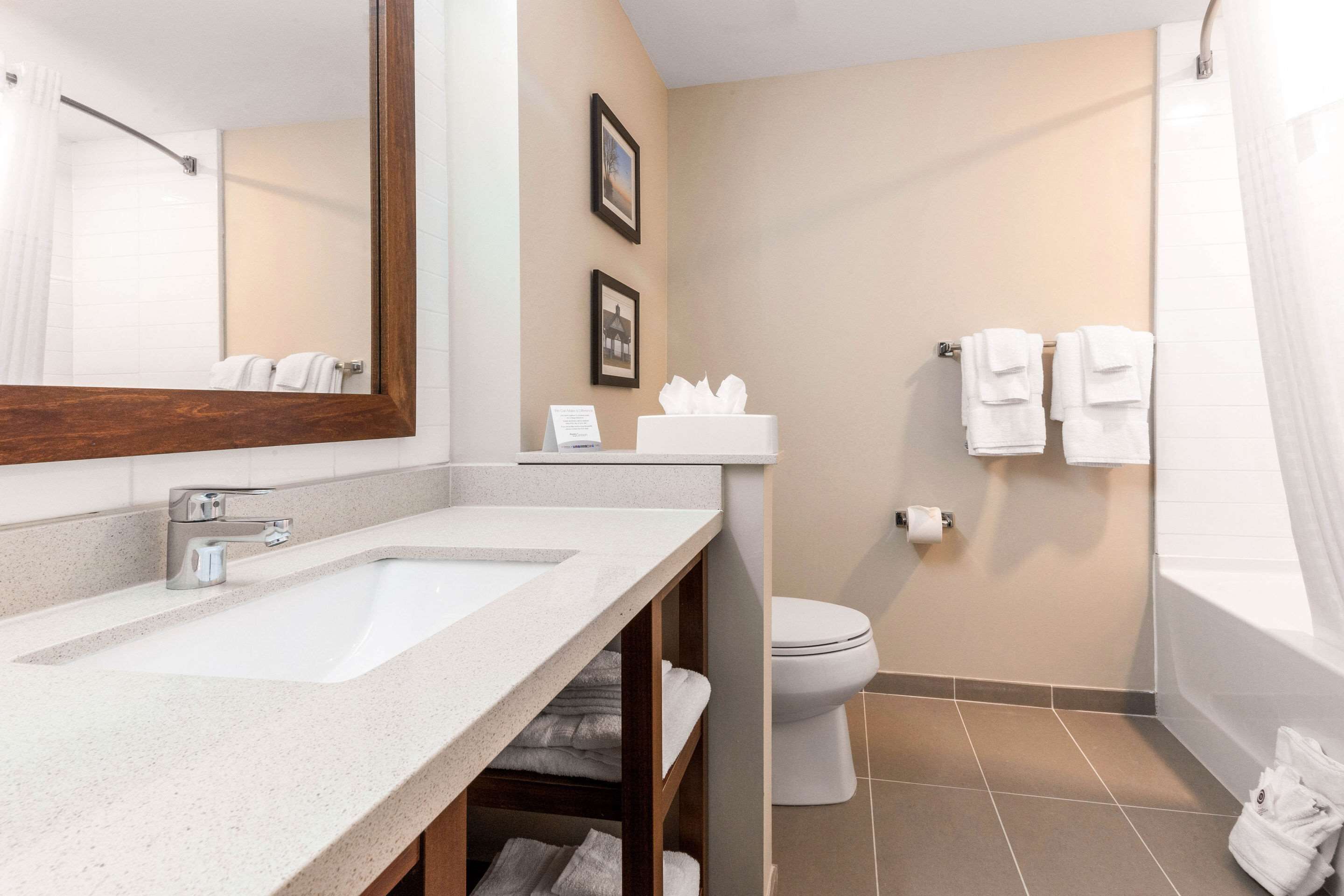 A bathroom with two sinks, a toilet, a bathtub, and towels.