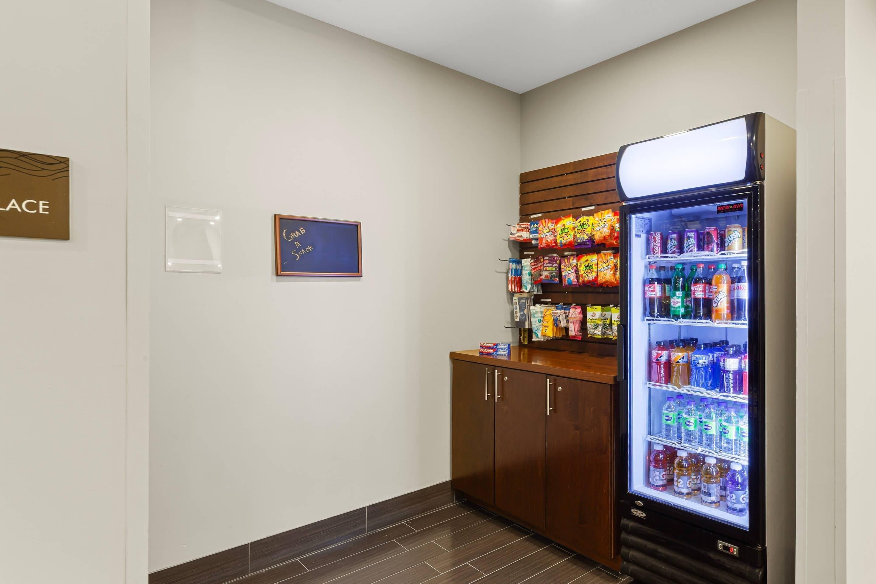 A vending machine with snacks and drinks, a wooden cabinet, and a sign on the wall.