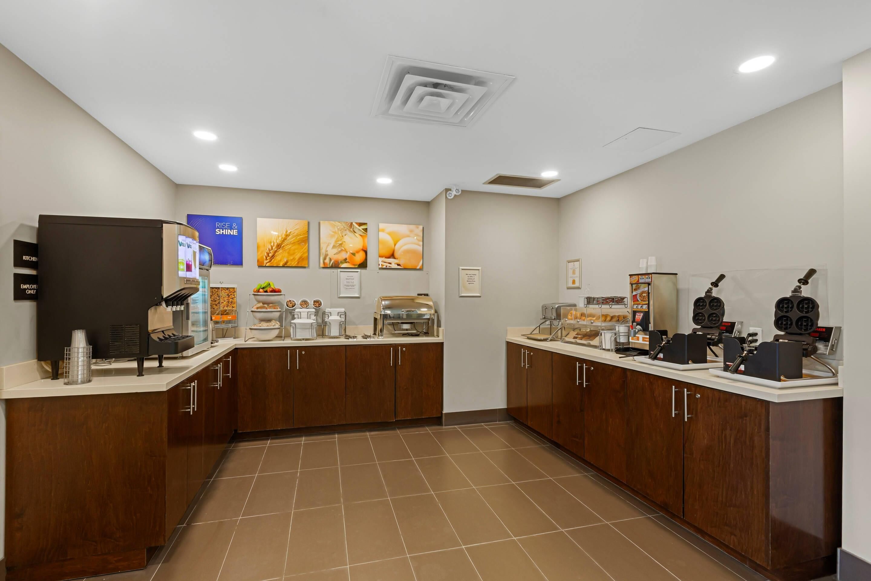A modern kitchen with a coffee station, a refrigerator, and a microwave.