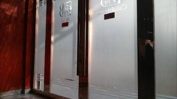 Un pasillo con puertas de vidrio esmerilado y una pared roja decorativa.