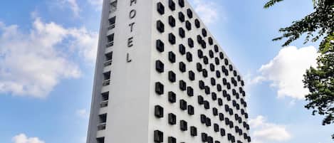 A tall hotel building with a prominent 'ibis' logo at the top.