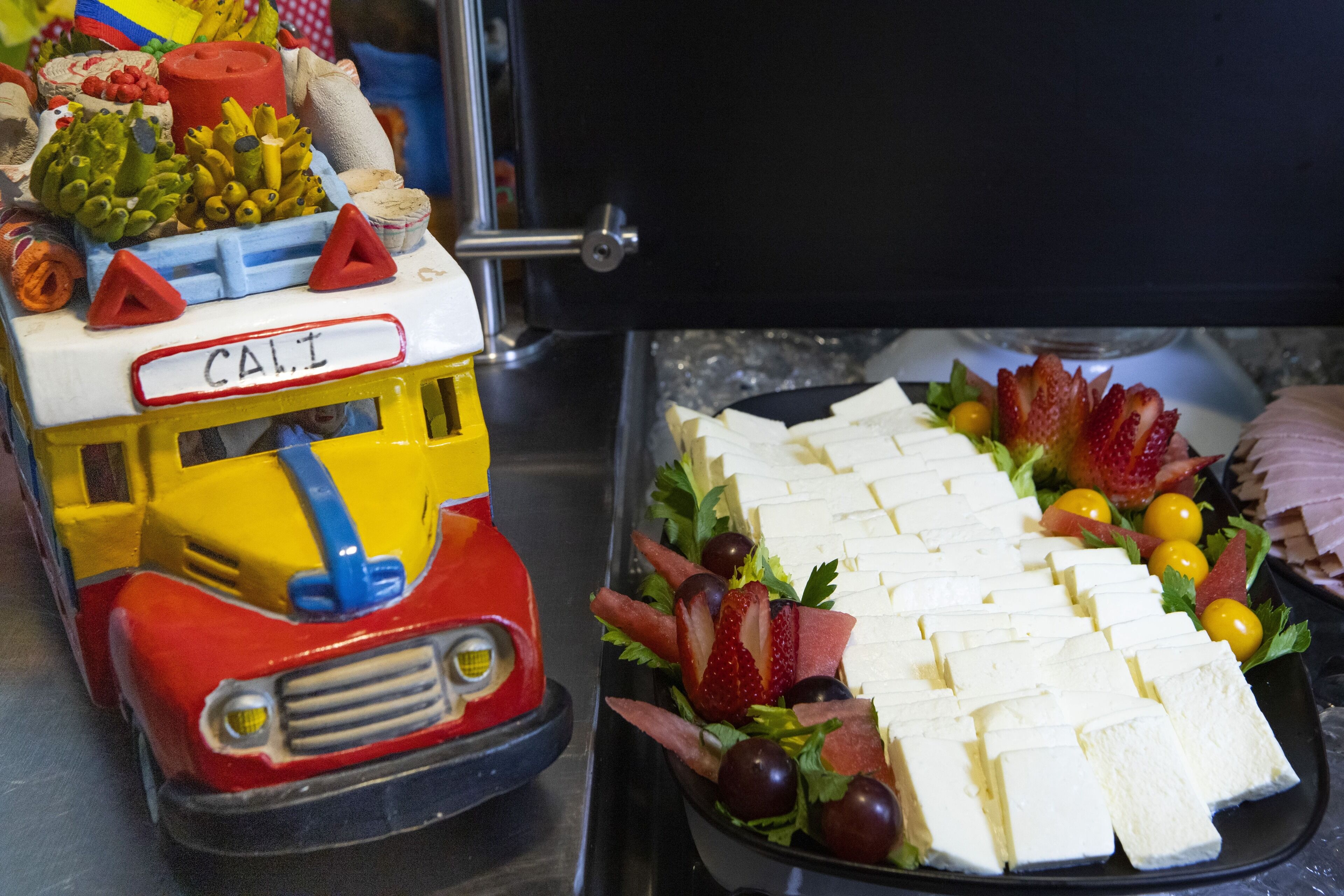 Un vehículo con la palabra “CAI” que transporta diversas frutas y verduras.