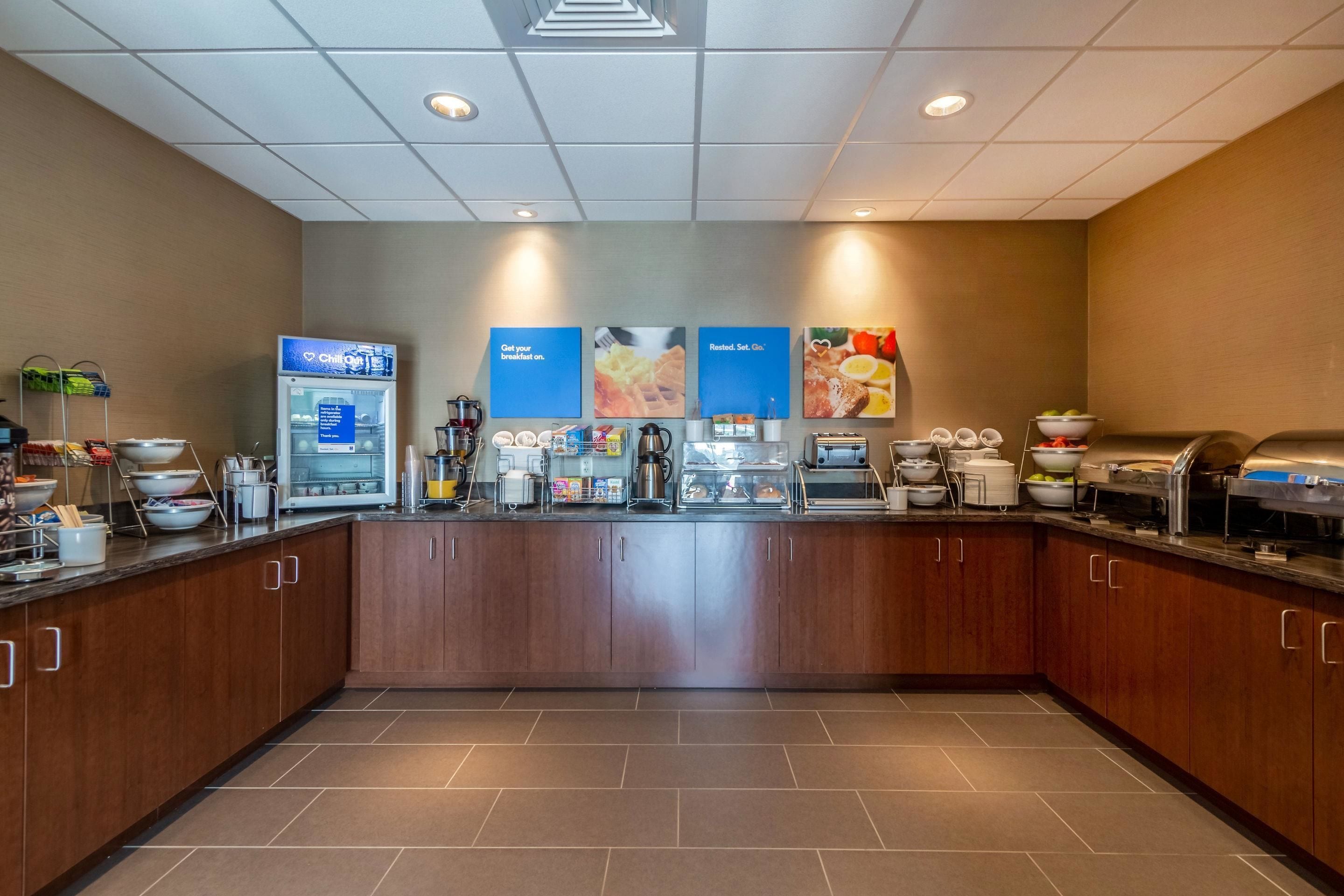 A modern kitchen with a central island, equipped with various appliances and food items.