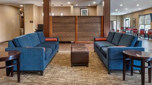 A lobby with two sofas, a coffee table, and a TV.