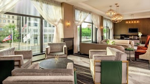 A spacious hotel lobby with a modern design, featuring a sofa set, a coffee table, and a television. - DoubleTree by Hilton Youngstown Downtown (Youngstown)