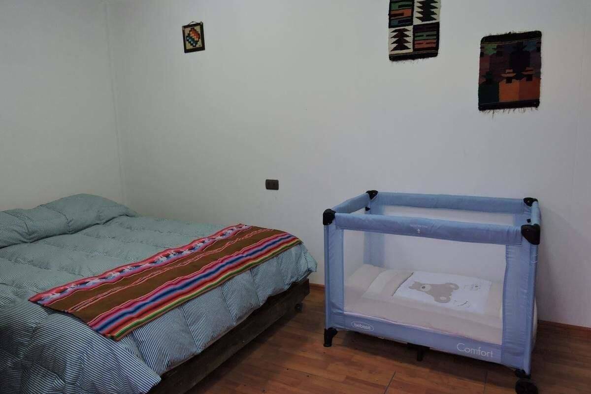 Une chambre à coucher avec un lit, un berceau et un plancher en bois.