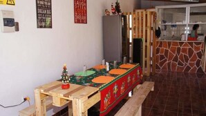 Ein Holztisch mit festlichem Tischläufer, eine kleine Weihnachtstanne und eine Bank.