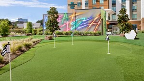 Un campo de golf con un edificio moderno al fondo.