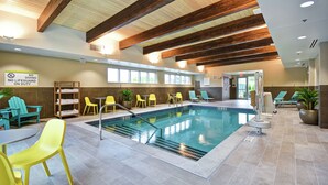 An indoor swimming pool with yellow and green chairs, a no diving sign, and a wooden ceiling. - Home2 Suites by Hilton Walpole Foxboro (Walpole)
