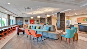 A modern lobby with a seating area, a bar, and a fireplace. - Home2 Suites by Hilton La Porte (La Porte)
