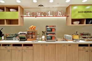 Ein Frühstücksbuffet mit einem Schild mit der Aufschrift "inspired table" und einem Schild mit der Aufschrift "GOOD MORNING" darüber.