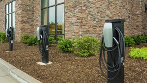 Edificio con tres estaciones de carga para vehículos eléctricos.