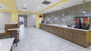 Una cocina moderna con mostrador, máquinas de café y suelo de baldosas.