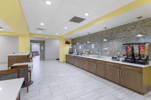 Una cocina moderna con mostrador, máquinas de café y suelo de baldosas.