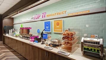 A breakfast counter with a sign reading 'TOP IT BREAKFAST' and menu options like waffles, eggs, and muffins.