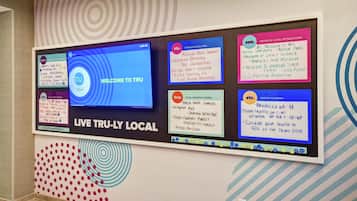A wall with various informational signs including a welcome sign, local attractions, and shopping options.