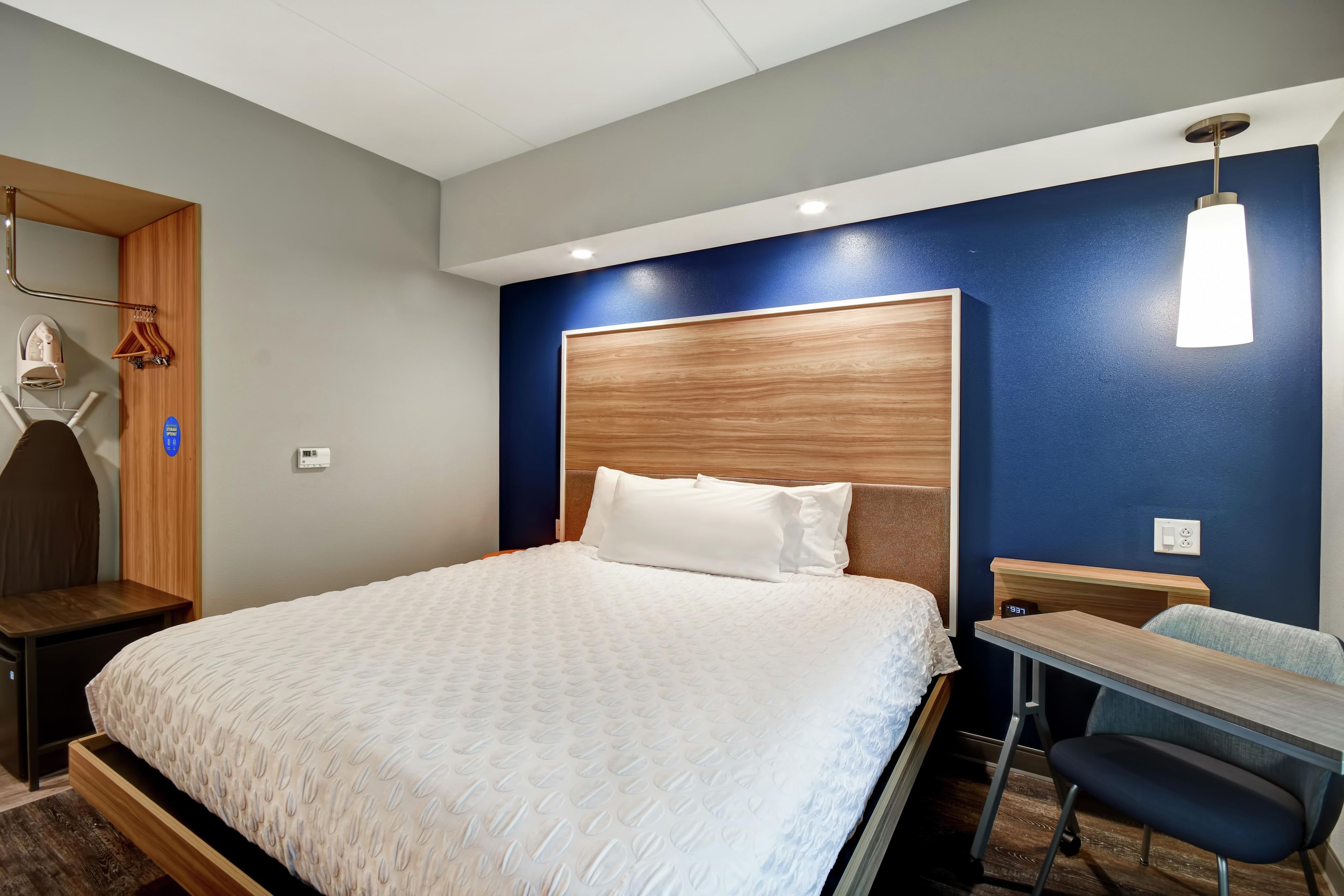 Een hotelkamer met een bed, een bureau en een stoel.