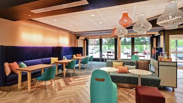 A modern interior with seating areas, tables, and a view of the outdoors.