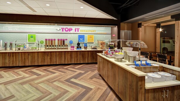 A breakfast counter with various food items and a sign that reads 'TOP IT BREAKFAST'. - Tru by Hilton Raleigh Durham Airport (Morrisville)