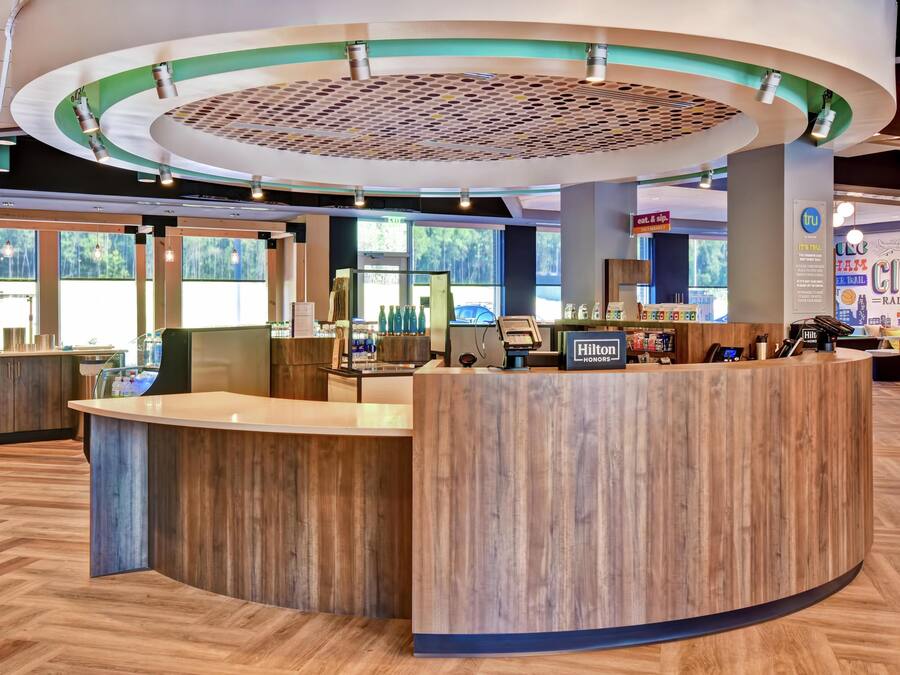 Ein Hotel-Empfangsbereich mit einem Holzbüro, großen Fenstern und einem kreisförmigen Deckenstil.