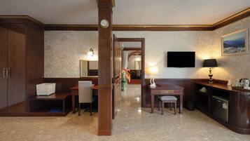 A hotel lobby with a reception desk, seating area, and a large mirror.