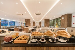 Un espace buffet proposant une variété de plats et de boissons, des panneaux de bois et un aménagement intérieur moderne.