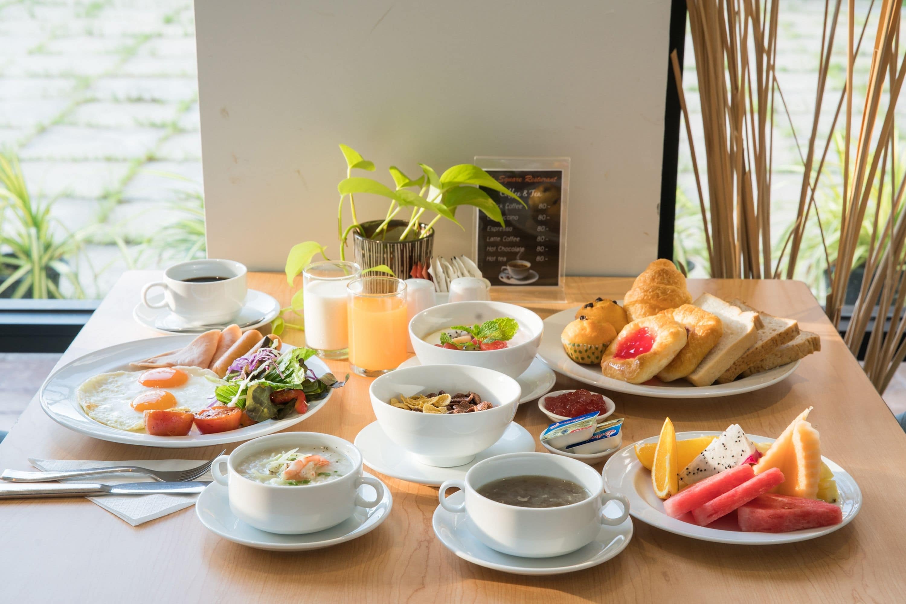 Et morgenbord med forskelligt mad, blandt andet æg, suppe, brød og frugt.