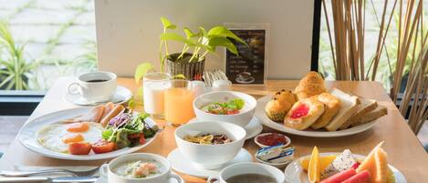 A breakfast table with various dishes including eggs, soup, bread, and fruit.