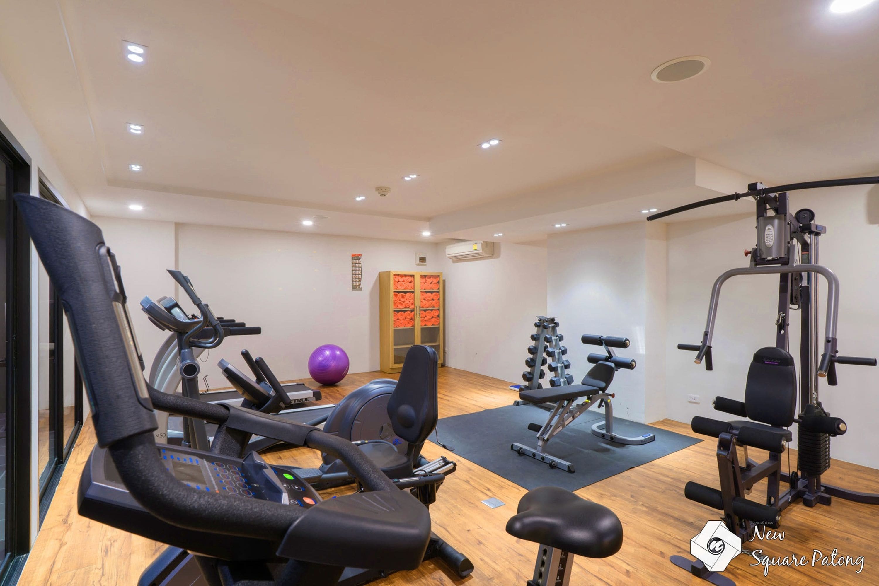 Une salle de sport équipée de matériel d’exercice, avec un ballon d’exercice violet et un porte-poids.