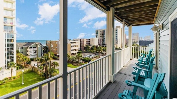A balcony with a view of the ocean and surrounding buildings. - 2000sq ft Villa 401, Ocean View steps to the beach, small pool hot tub 4 king bd (North Myrtle Beach)
