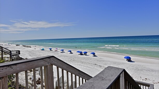 A beach with wooden walkways and blue umbrellas. - Sunseeker - Xanadu by Coastal Dreamin (Santa Rosa Beach)