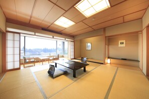 A traditional tatami room with a low table, chairs, and sliding doors.