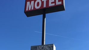 Une enseigne de motel indiquant « ARISTOCRAT MOTEL », avec une autre enseigne en dessous indiquant « CHAMBRES LIBRES ».