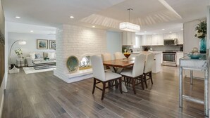 Una cocina moderna con armarios blancos, una isla central y electrodomésticos de acero inoxidable.