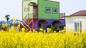 Een meerlaags gebouw met een buitenkant in groen en paars, een houten trap en een balkon.
