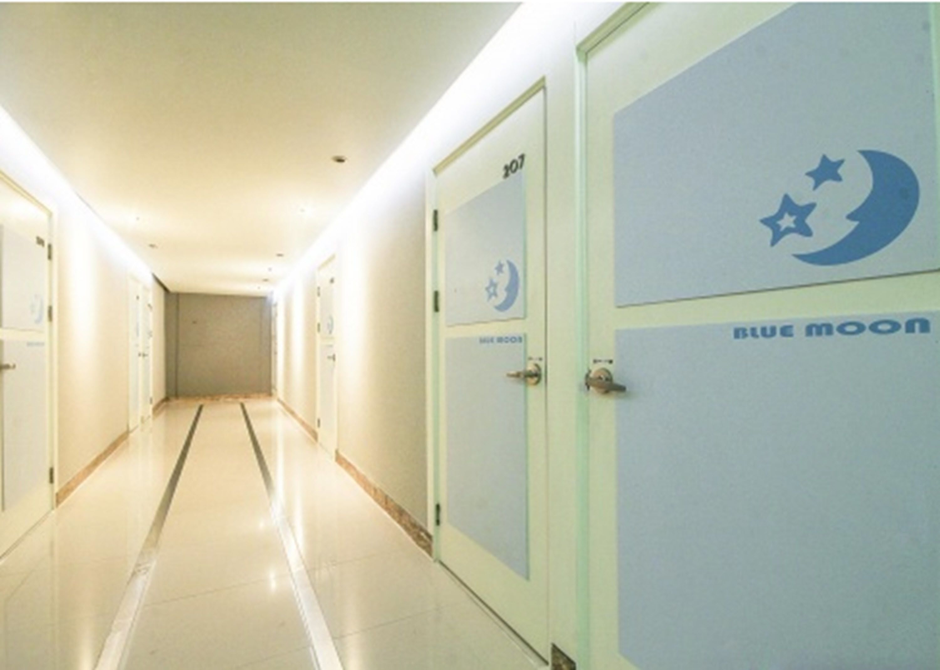 A hallway with doors labeled "Blue Moon" and "107".