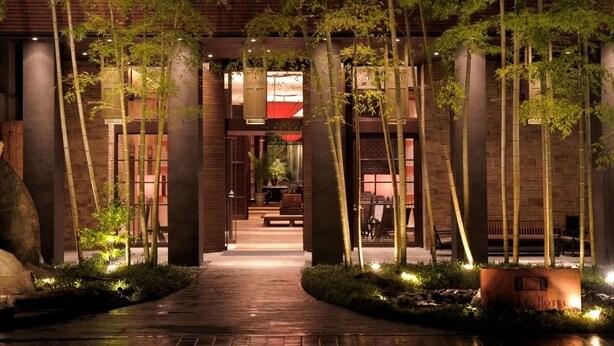 A pathway leading to a building with bamboo trees and a brick facade. - Urban Villa Konaya Hotel (Kofu)