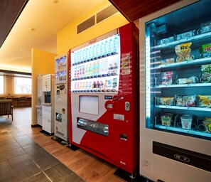 A vending machine with a Coca-Cola logo, a beverage dispenser, and a refrigerated section with snacks. - ホテルB4T角館 (Senboku)
