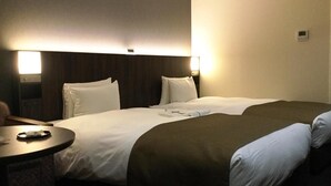A hotel room with a large bed, a bedside table, and a wall-mounted lamp. - ホテルB4T角館 (Senboku)
