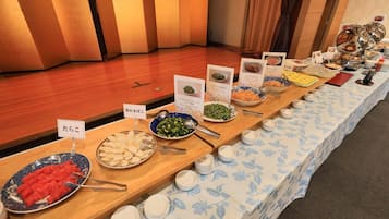 Une table de buffet proposant divers plats et comportant des étiquettes, dans un cadre hôtelier.