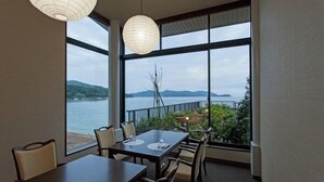 Un espace repas offrant une vue sur la mer et les montagnes.