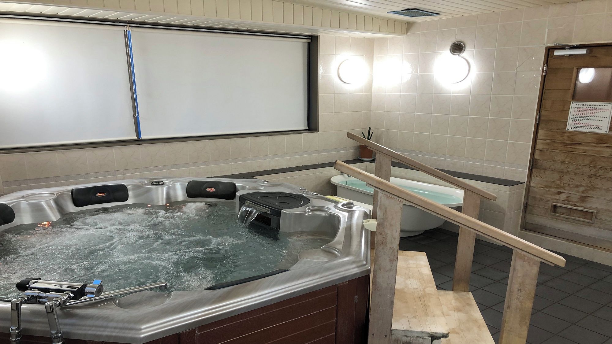 A bathroom with a hot tub, a toilet, and a shower area.