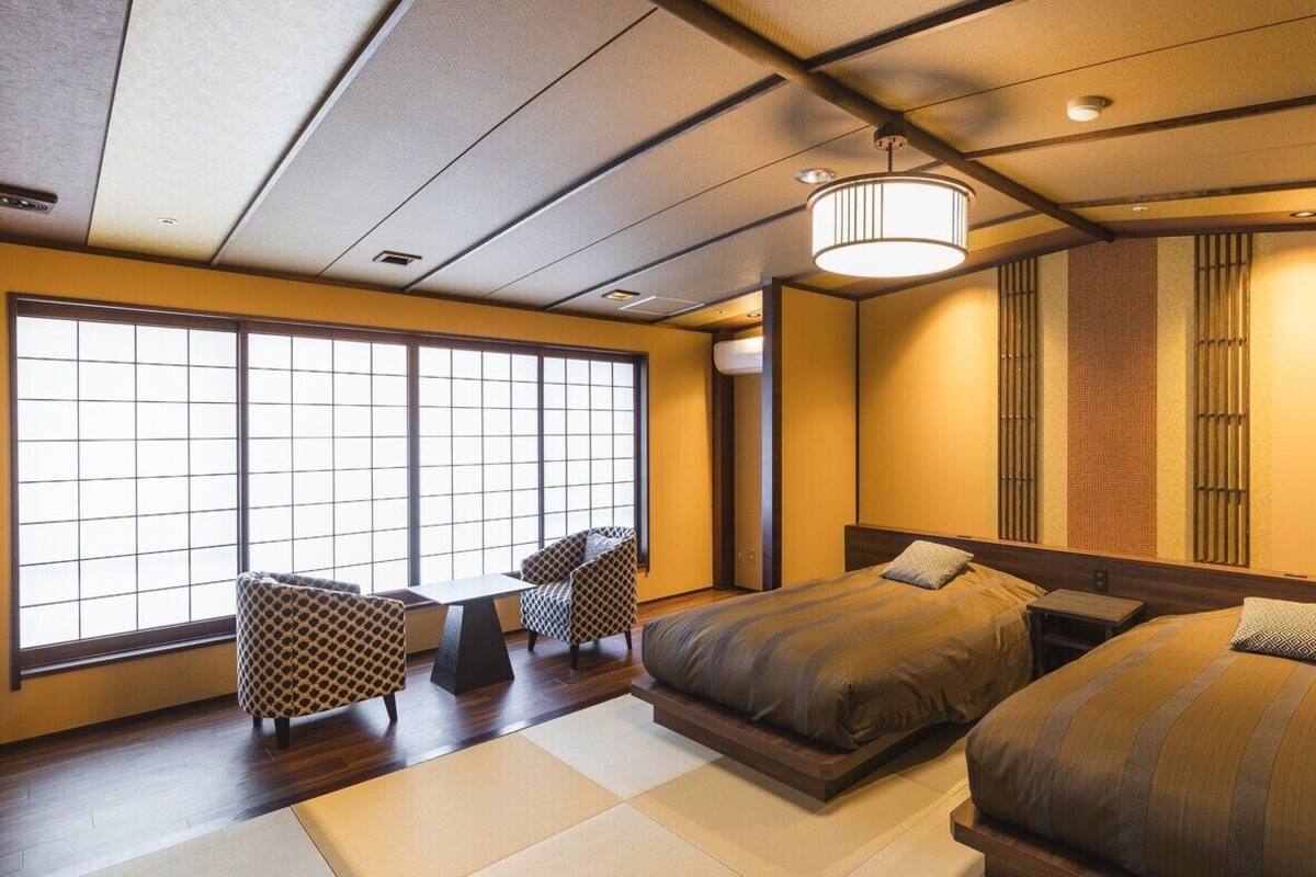 Un dormitorio tradicional japonés con suelo de tatami, un fusuma y un ventanal grande.