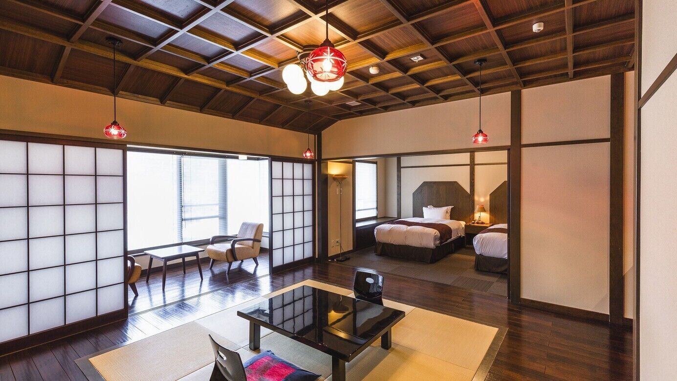 A traditional Japanese-style room with tatami flooring, sliding doors, and a low ceiling.