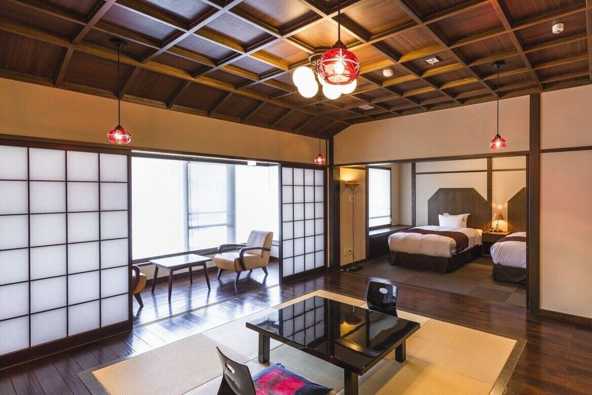 Una habitación tradicional japonesa con suelo de tatami, puertas correderas y techo bajo.