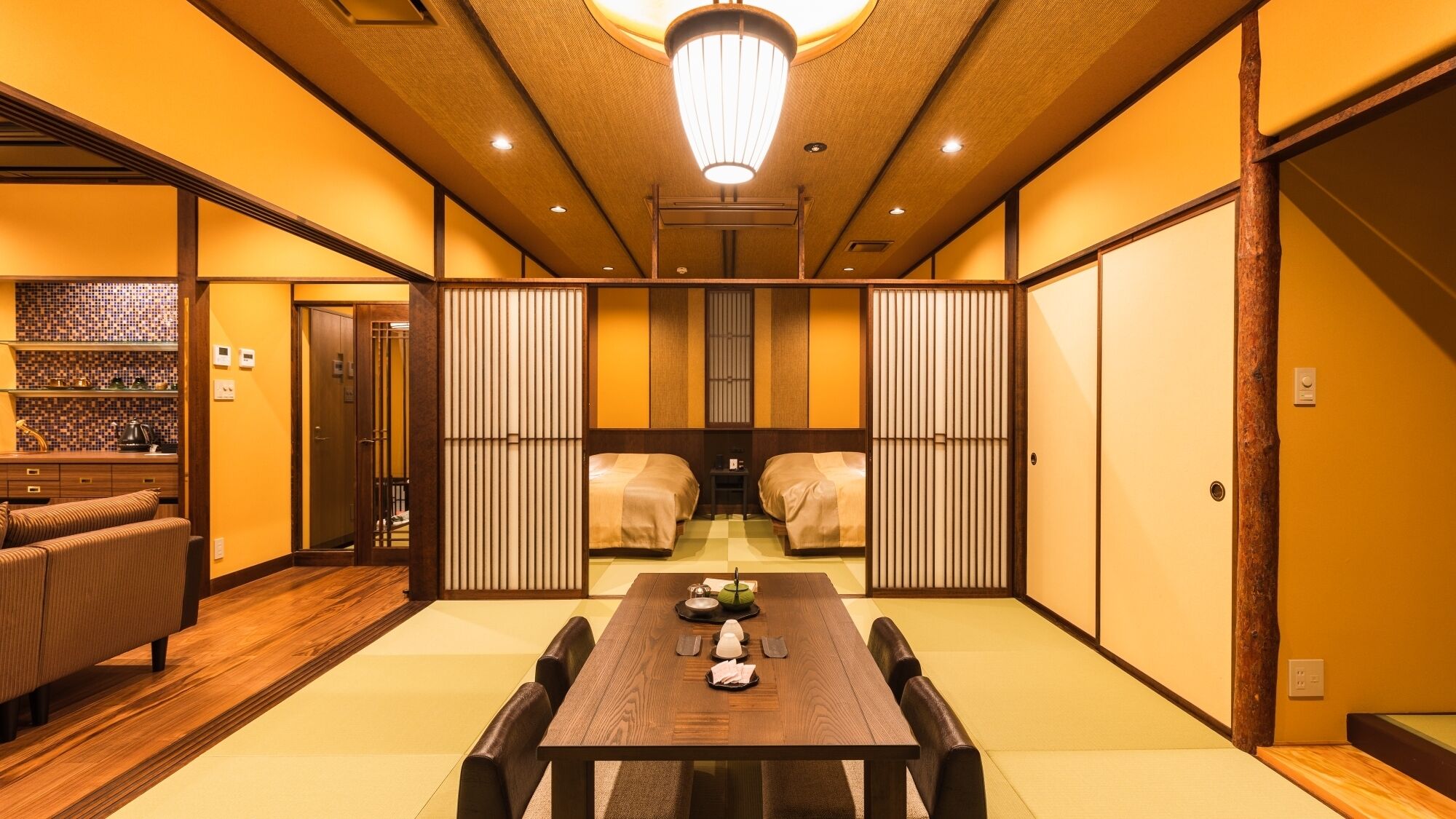 A traditional Japanese room with tatami flooring, a low table with a tea set, and sliding doors.
