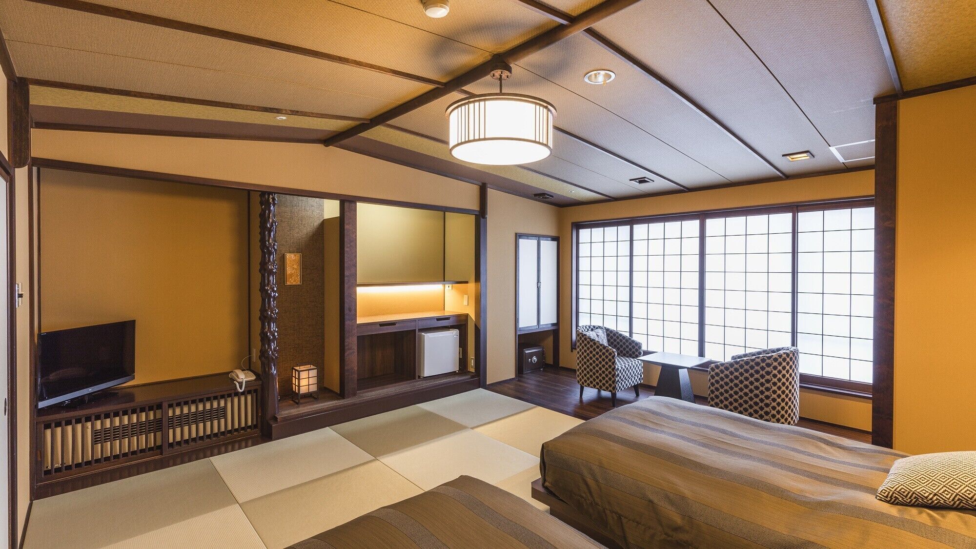 A traditional Japanese-style room with tatami flooring, a bed, a television, and a sliding door.