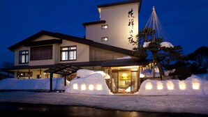 A traditional Japanese building with a snow-covered entrance and illuminated signage. - Kazennosyo (Kuroishi)